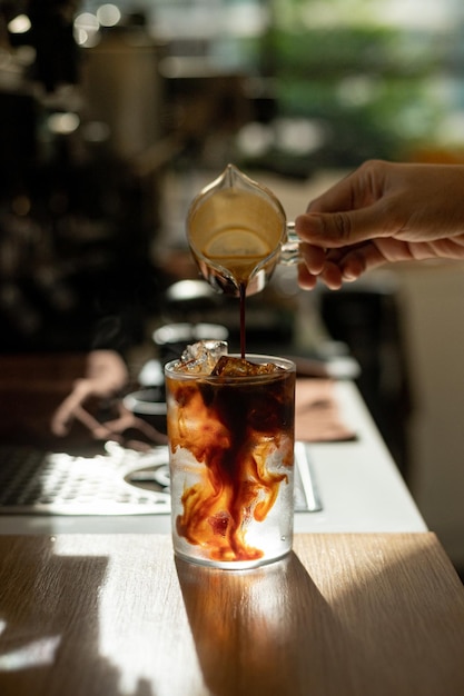 Eiskaffee im Glas auf schwarzem Holztisch im Café