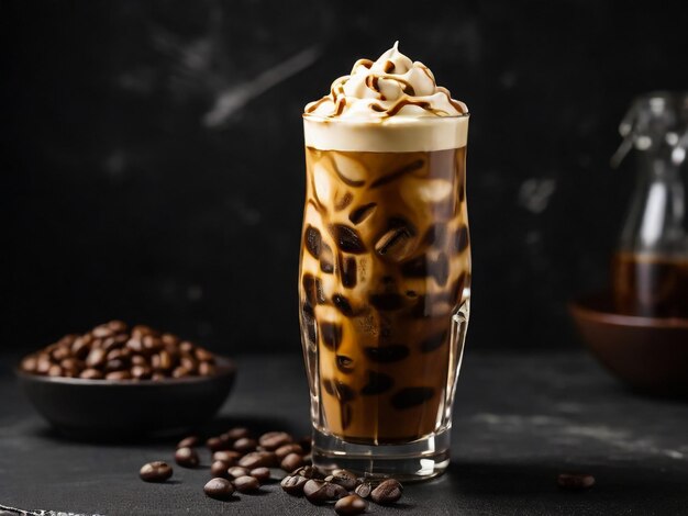 Eiskaffee in einem hohen Glas mit Sahne, die über Eiswürfel und Bohnen auf einem dunklen Betontisch gegossen wird