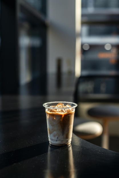 Eiskaffee in Plastikglas auf schwarzem Tisch im Café