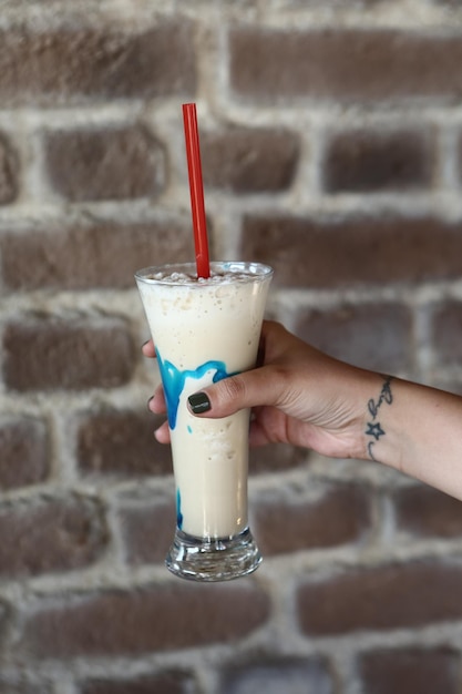 Eiskaffee mit Milch. Eiskaffee Latte. Frau mit Glastasse Eiskaffee.