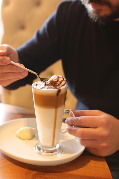 Eiskaffee mit Milch. Eiskaffee Latte. Frau mit Glastasse Eiskaffee.