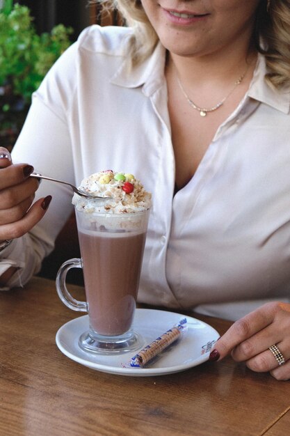 Eiskaffee mit Milch. Eiskaffee Latte. Frau mit Glastasse Eiskaffee.