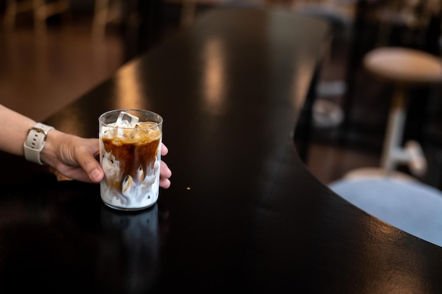 Eiskaffee mit Milch in einem Glas auf einem Tisch in einem Café