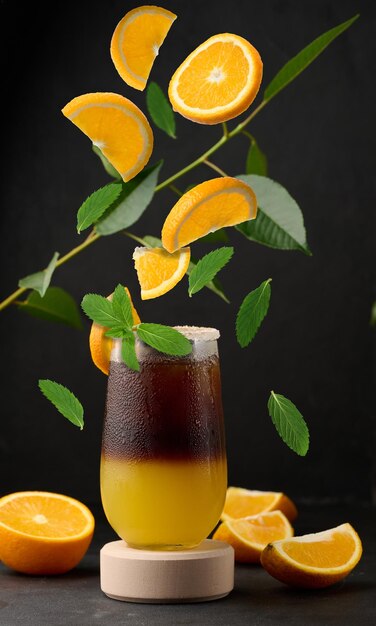 Eiskaffee mit Orangensaft in einem transparenten Glas, erfrischender Hummelkaffee auf dem Tisch