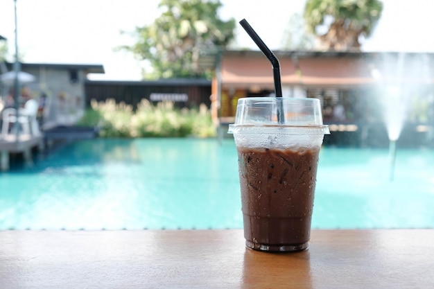 Eiskakao süß und erfrischend Auf dem Holzboden neben dem Pool in einem modernen Café