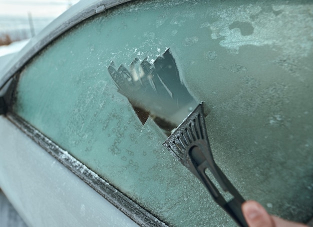 Eiskratzen am Autofenster Konzept der Fahrzeugvorbereitung für eine Fahrt bei Minusgraden