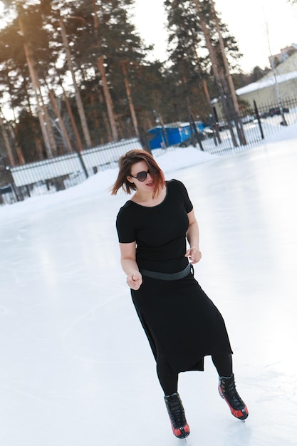 Eiskunstläuferin auf dem Eis. das Mädchen ist Schlittschuhlaufen. Eis unter freiem Himmel. Kein Make-up im Winter, rote Wangen