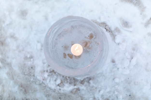 Eislaterne mit brennender Kerze im Inneren