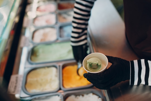 Foto eismaschine legt buntes eis außerhalb der tasse