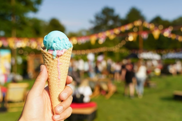 Eiswaffel in der Hand Süßes Dessert auf Sommerpicknick verschwommenem Hintergrund Essen Sommereis