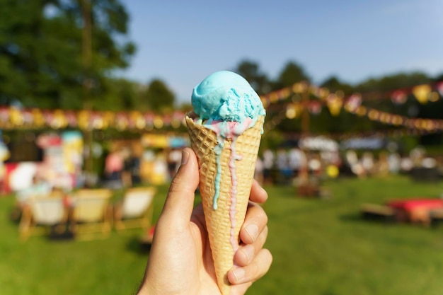 Eiswaffel in der Hand Süßes Dessert auf Sommerpicknick verschwommenem Hintergrund Essen Sommereis