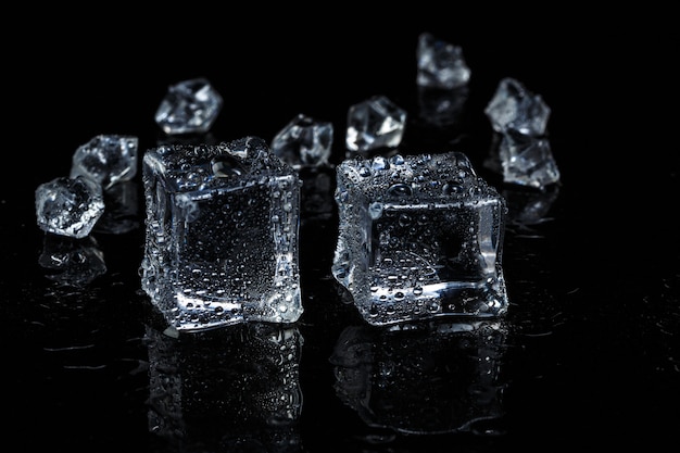 Eiswürfel auf schwarzem isoliertem Glashintergrund