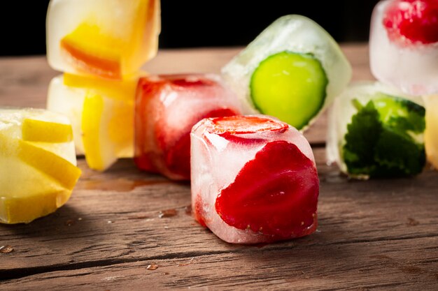 Eiswürfel mit Früchten auf Holztisch. Heißes Sommerkonzept, Nachtisch