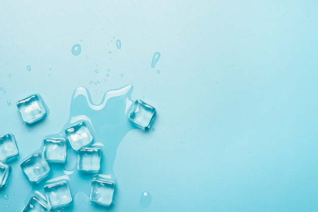 Eiswürfel mit Wasser auf blauem Grund. Eiskonzept für Getränke.