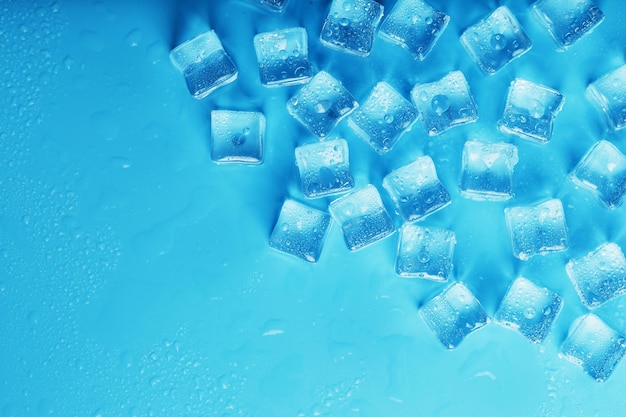 Eiswürfel mit Wassertropfen zerstreut auf einer Draufsicht des blauen Hintergrundes