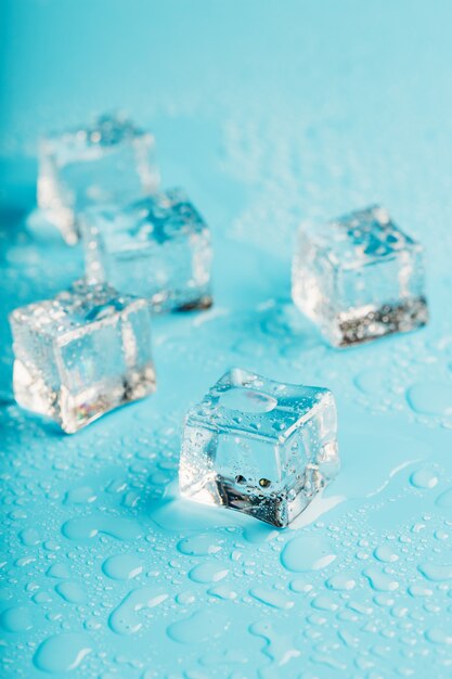 Eiswürfel sind mit Wassertropfen verstreut.