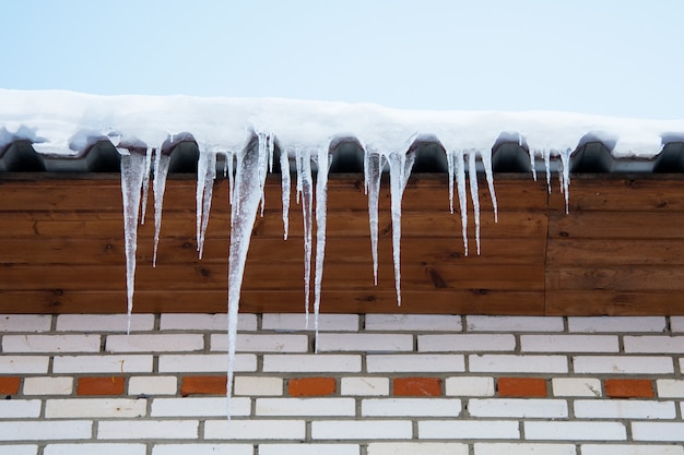 Foto eiszapfen hängen auf dem dach