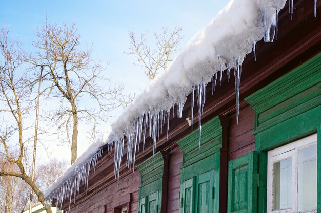 Eiszapfen hängen vom Dach des Hauses