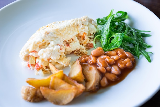 Foto eiweißomelette mit bohnenkartoffeln und salat, gesundes frühstück