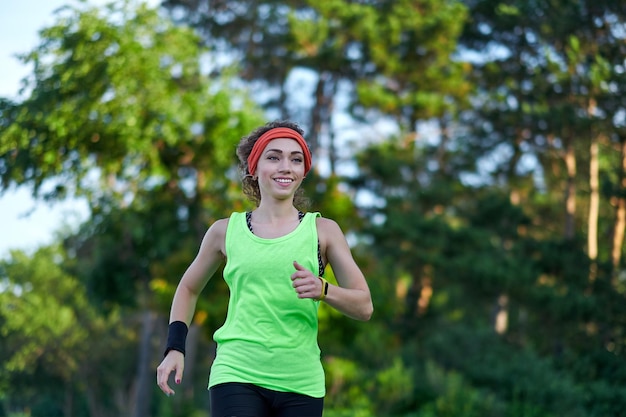 Ejecutando mujer corredora trotar durante el entrenamiento al aire libre en un parque hermoso ajuste chica modelo de fitness al aire libre pérdida de peso