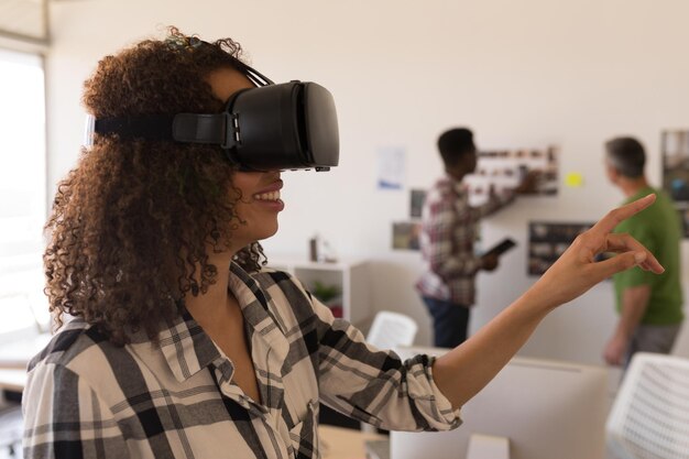 Ejecutiva femenina con casco de realidad virtual en Office