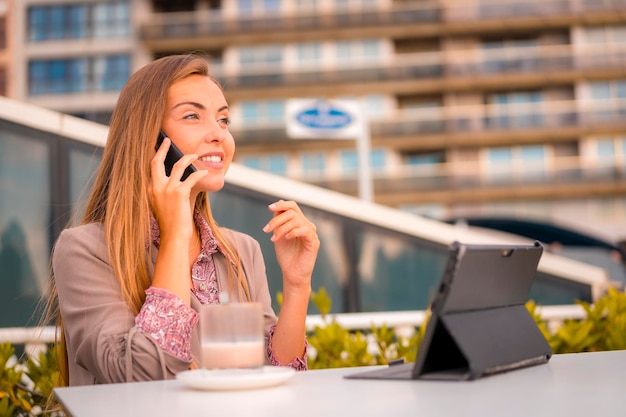 Ejecutiva mujer rubia empresaria desayunando café descafeinado en una llamada de trabajo