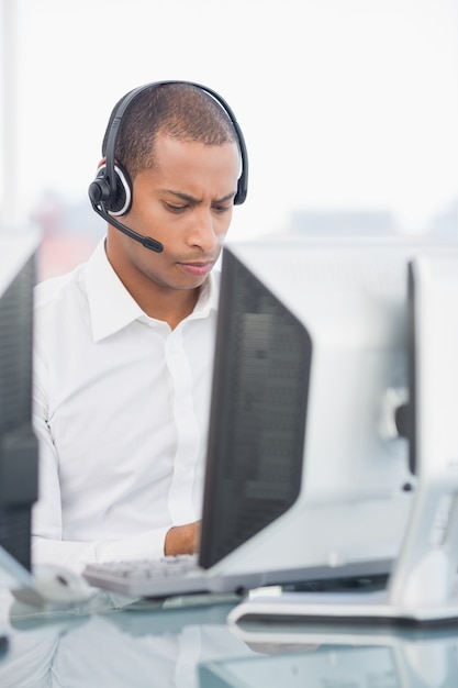 Foto ejecutivo con auriculares usando la computadora en el escritorio