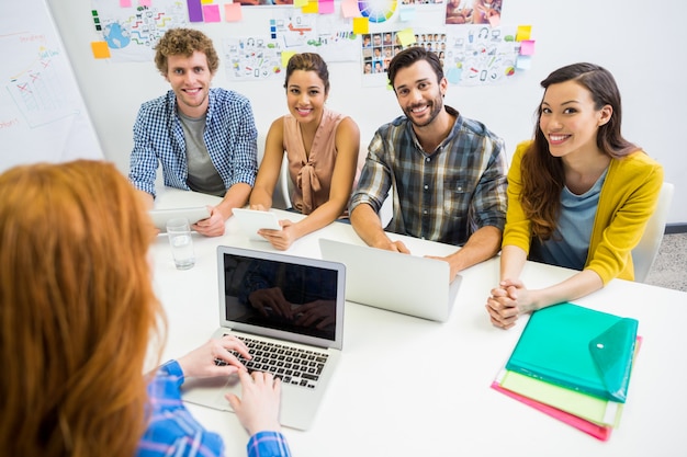 Ejecutivo discutiendo sobre laptop con sus colegas durante la reunión