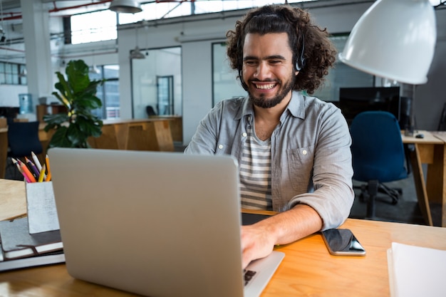 Ejecutivo con laptop en oficina creativa