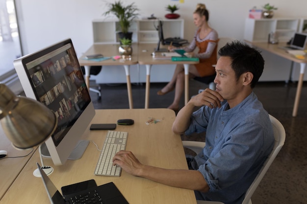 Foto ejecutivo masculino trabajando en una computadora personal en el escritorio