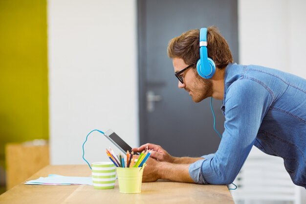 Foto ejecutivo de negocios escuchando música en tableta digital