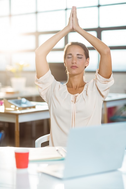 Foto ejecutivo de negocios femenino que realiza yoga