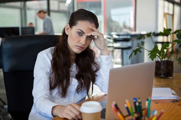 Ejecutivo de negocios femenino sentado con laptop