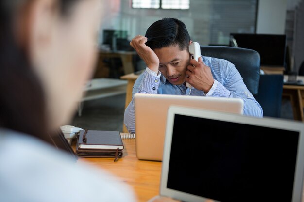 Ejecutivo de negocios frustrado hablando por teléfono