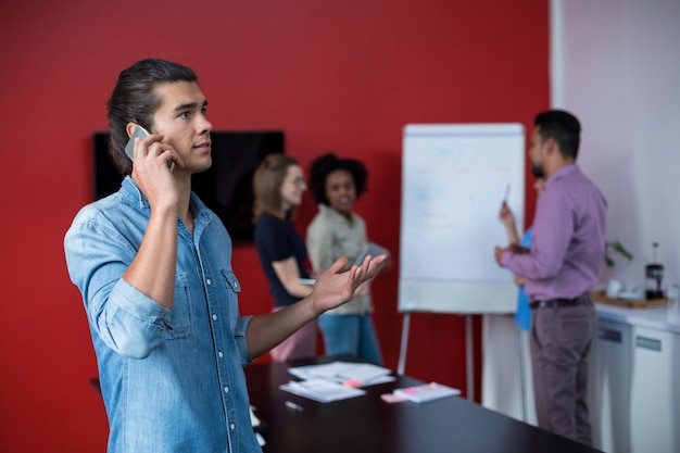 Foto ejecutivo de negocios hablando por teléfono móvil en reunión