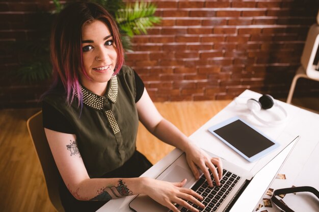 Ejecutivo sonriente que trabaja en la computadora portátil en la oficina