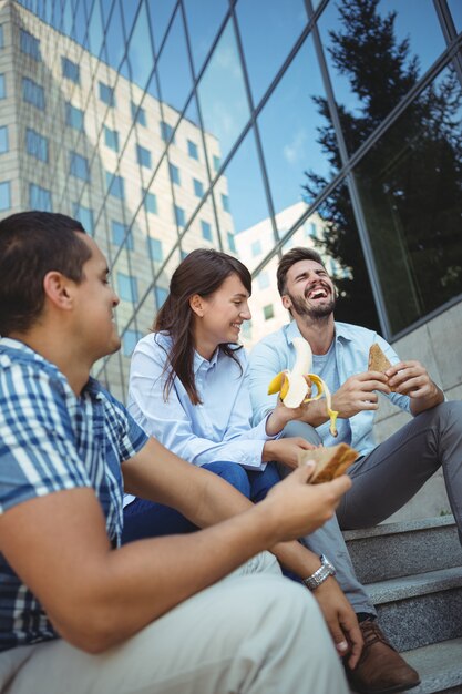 Ejecutivos desayunando fuera del edificio de oficinas