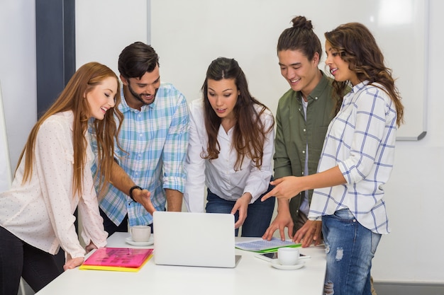 Foto ejecutivos discutiendo sobre laptop en la sala de conferencias