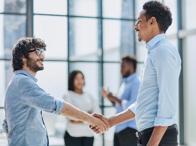 Los ejecutivos exitosos de colaboración empresarial saludan con un apretón de manos en la oficina