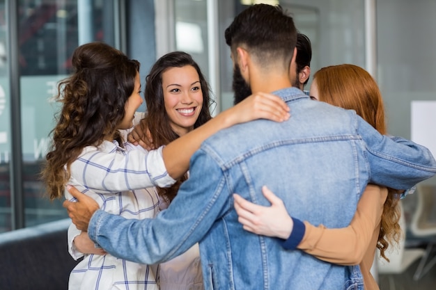 Ejecutivos felices formando círculo en la oficina