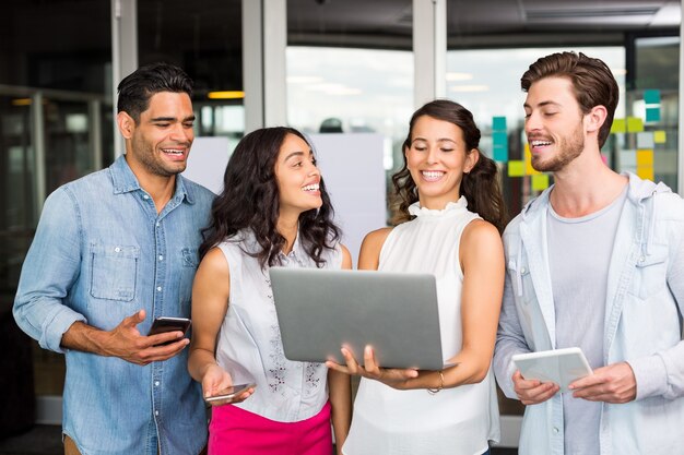 Foto ejecutivos felices usando laptop, tableta digital y teléfono móvil