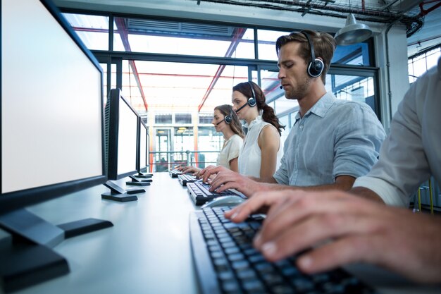 Ejecutivos de negocios con auriculares usando computadora