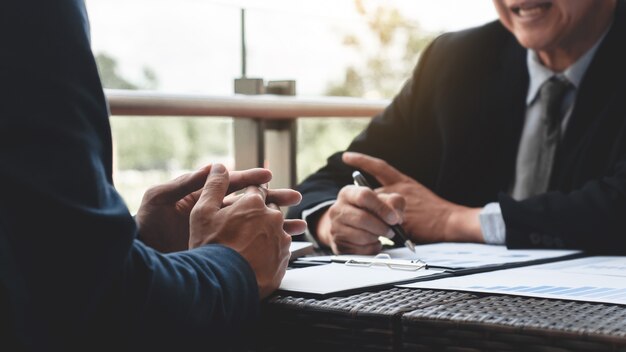 Ejecutivos de negocios discutiendo sobre el desempeño de ventas en un moderno lugar de trabajo al aire libre.