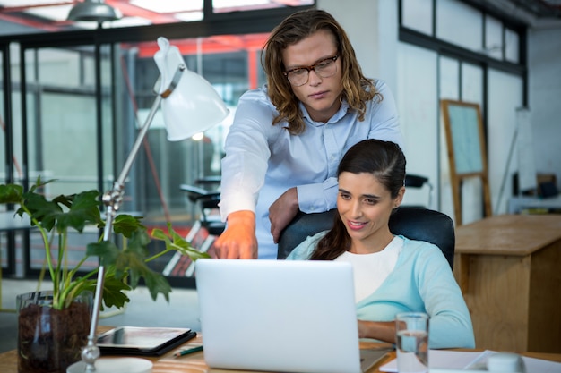 Ejecutivos de negocios discutiendo sobre laptop