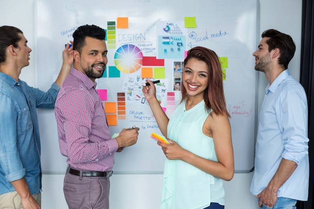 Foto ejecutivos de negocios discutiendo sobre tablero blanco en la oficina