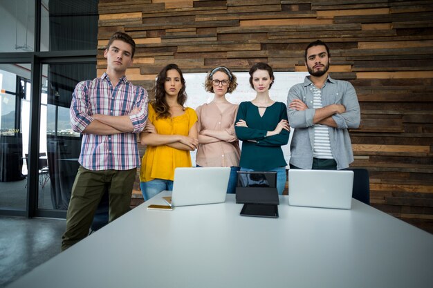 Foto ejecutivos de negocios de pie con los brazos cruzados en la oficina