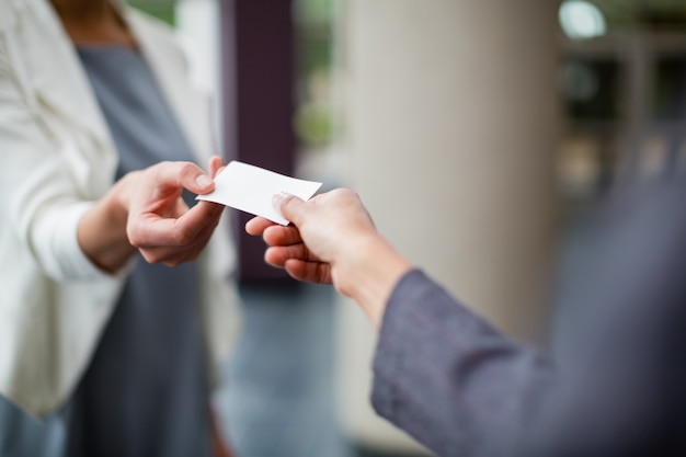 Foto ejecutivos de negocios que intercambian tarjetas de visita