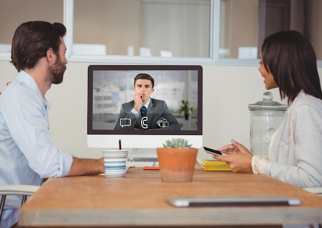 Ejecutivos de negocios que tienen videollamadas con un colega en una computadora de escritorio