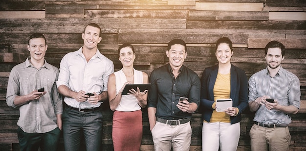 Ejecutivos de negocios sonrientes que usan teléfonos móviles y tabletas digitales