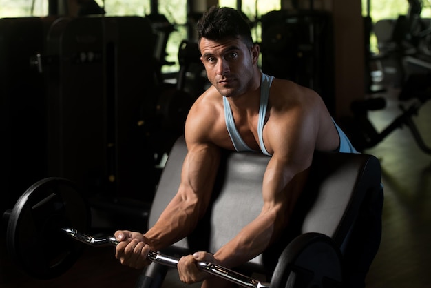 Ejercicio de bíceps con barra en un gimnasio